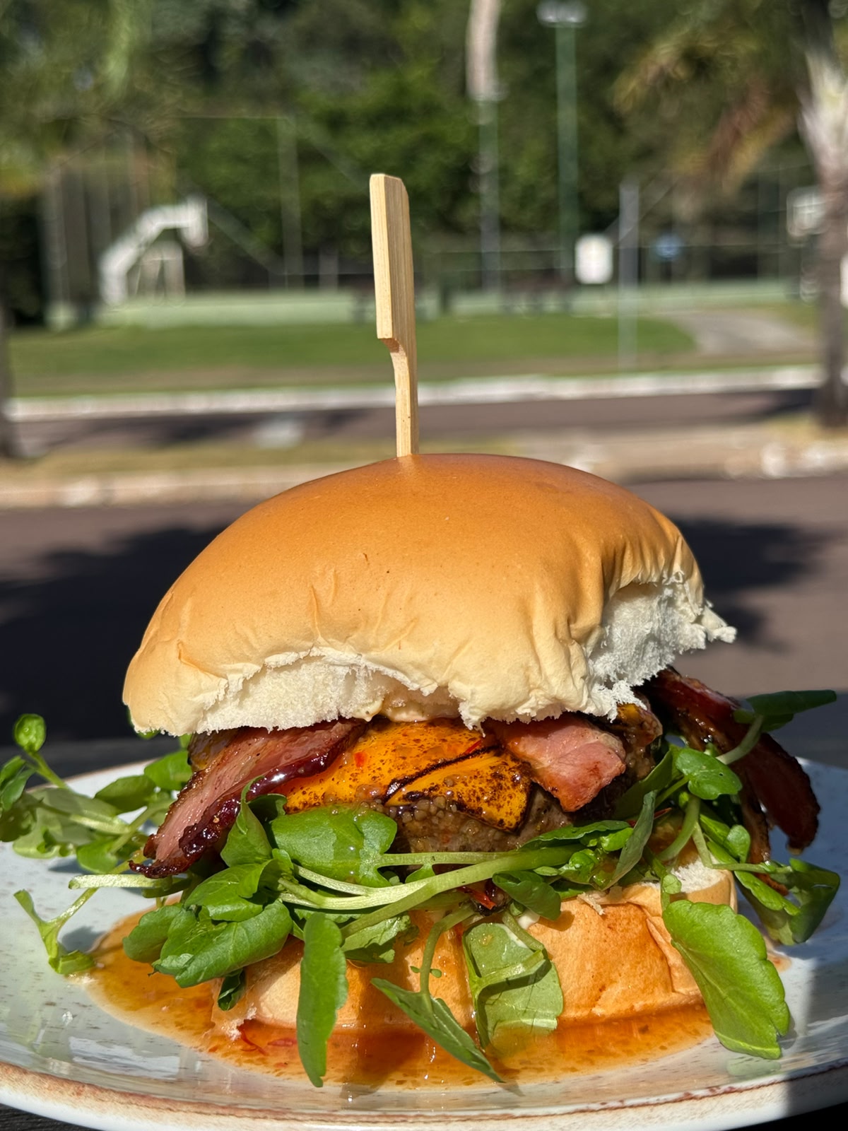 Hambúrguer com queijo, bacon e folhas verdes do Na Orla